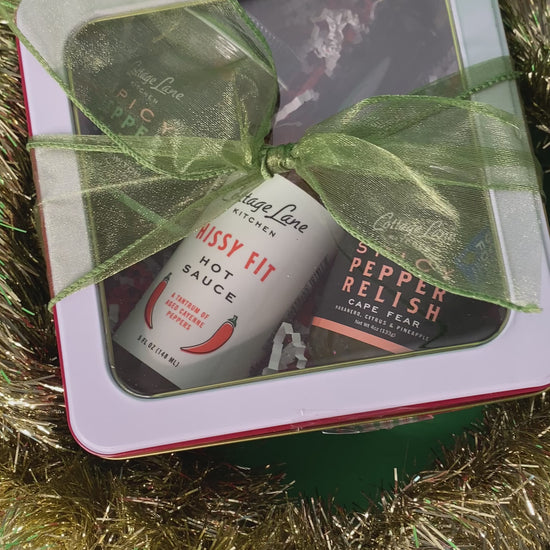 video showing close up of Cottage Lane Kitchen products in a clear box that is gift wrapped in a green ribbon and surrounded by gold tinsel